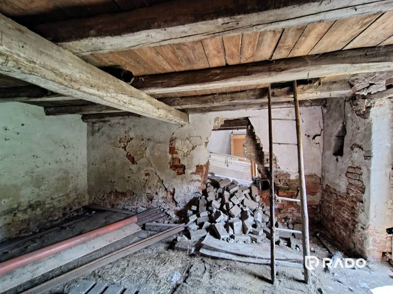 Old walls, wooden ceiling, and building material in a family house.