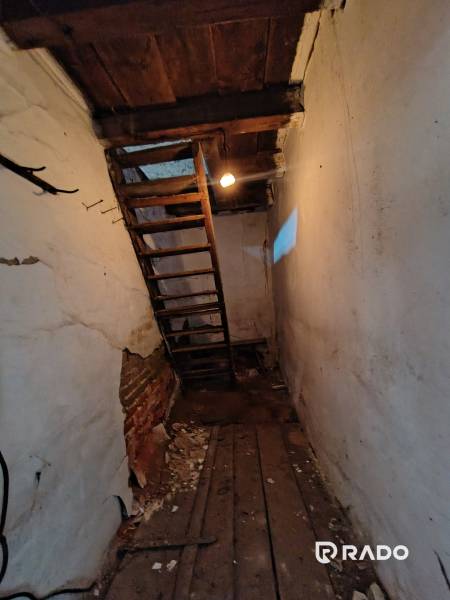 A narrow passage with a ladder and a wooden ceiling in a family house.