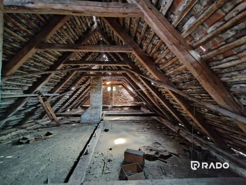The attic of a family house with an old wooden beam roof structure and a pitched roof.