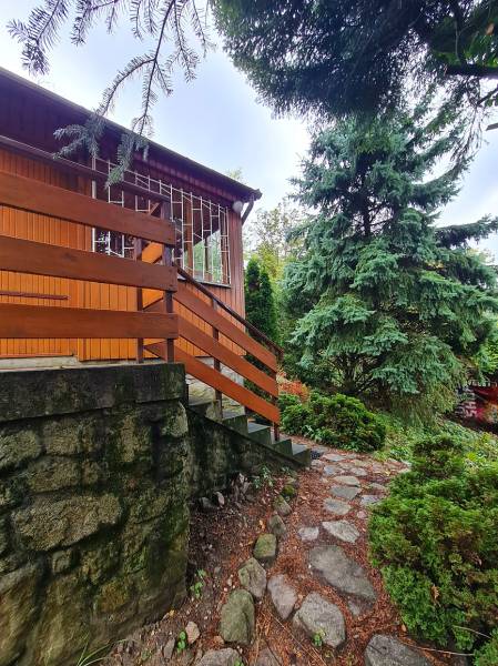 A wooden house with a garden and a stone path in Tavarikova Settlement in Bratislava - Dúbravka. Construction of houses.