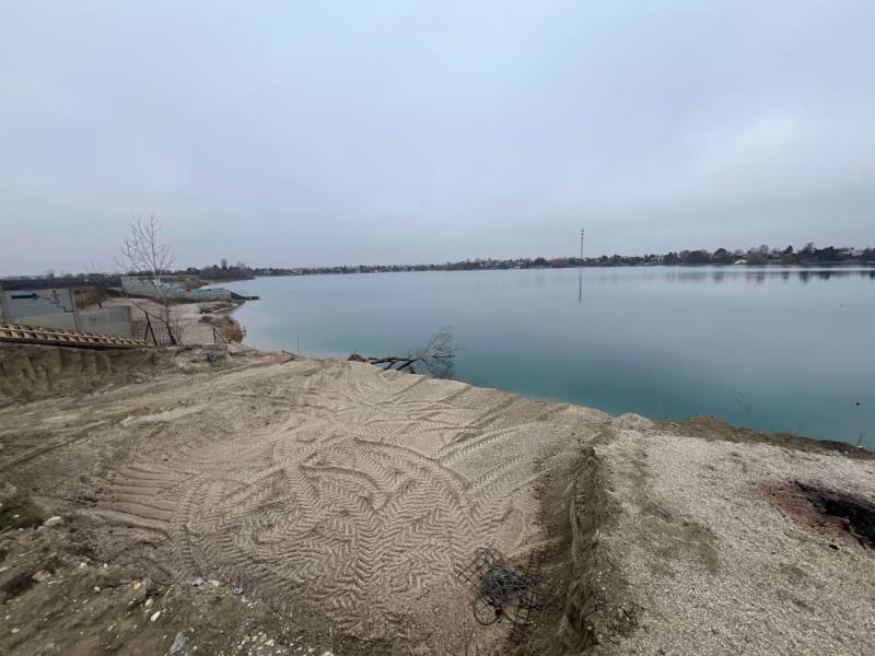 A lake surrounded by a sandy shore, on Veľké Košariská Street, Recreational plots.