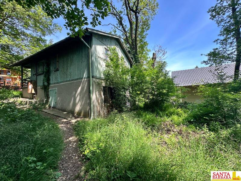 Cottage on Harmony in Modra with surrounding greenery and adjacent building.