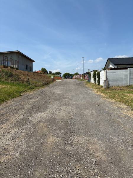 A gravel road leads to the houses in Gregorovce, ideal for residential plots.