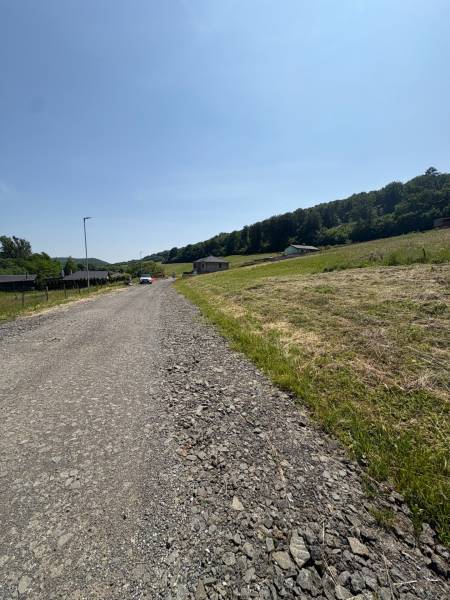 A visible path leading through residential lands in the town of Gregorovce with surrounding nature.