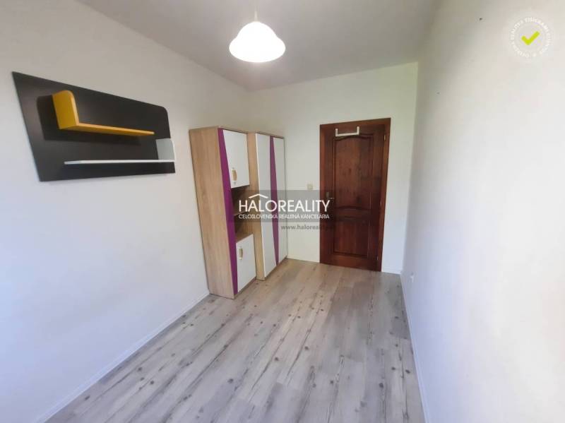 A small room with a wooden floor, a wardrobe, and original wall decoration in a 4-room apartment.