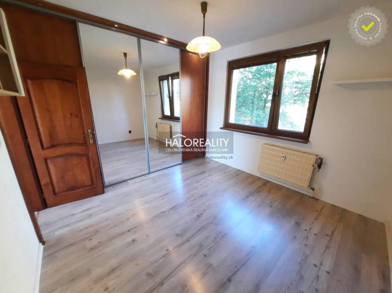 A room in a 4-room apartment with a wooden floor, a mirrored wardrobe, and a window.