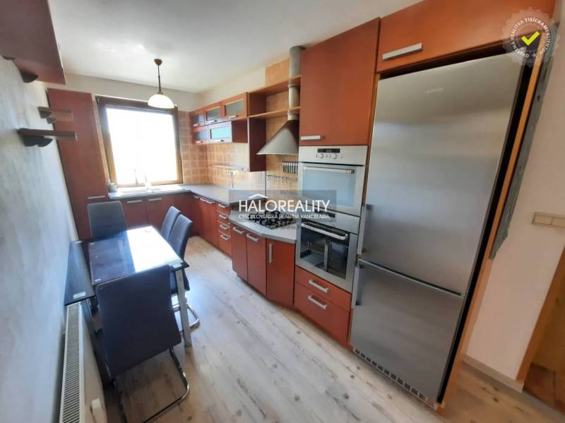 A kitchen in a 4-room apartment with built-in appliances and a dining table.