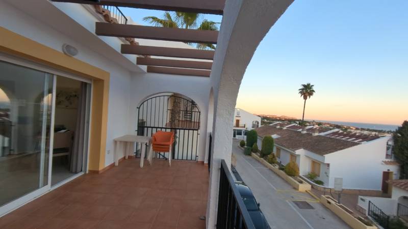The balcony of the holiday apartment in Calpe offers a view of the sea and the rooftops of houses.
