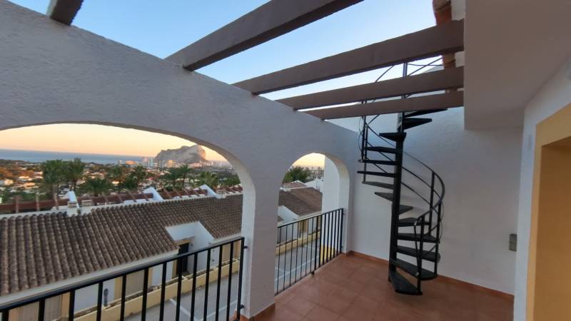 Balcony of a holiday apartment in Calpe with a sea view and a spiral staircase.