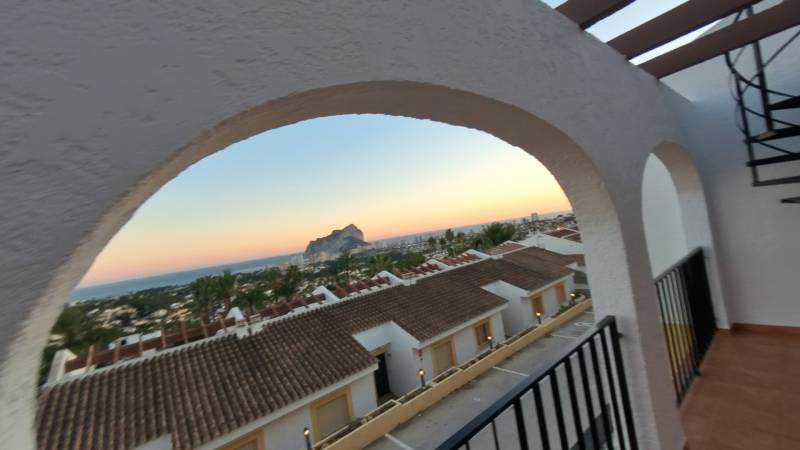 View from a holiday apartment in Calpe of the sea and rooftops during sunset.