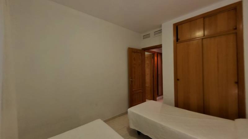 Two single beds and a wooden wardrobe in the Holiday Apartment.