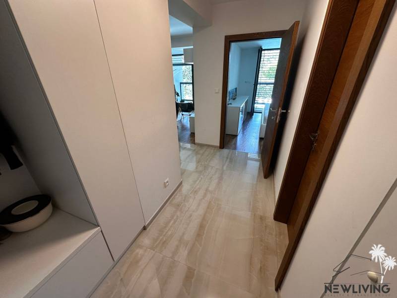A hallway with tiles and built-in wardrobes in a 2-room apartment.