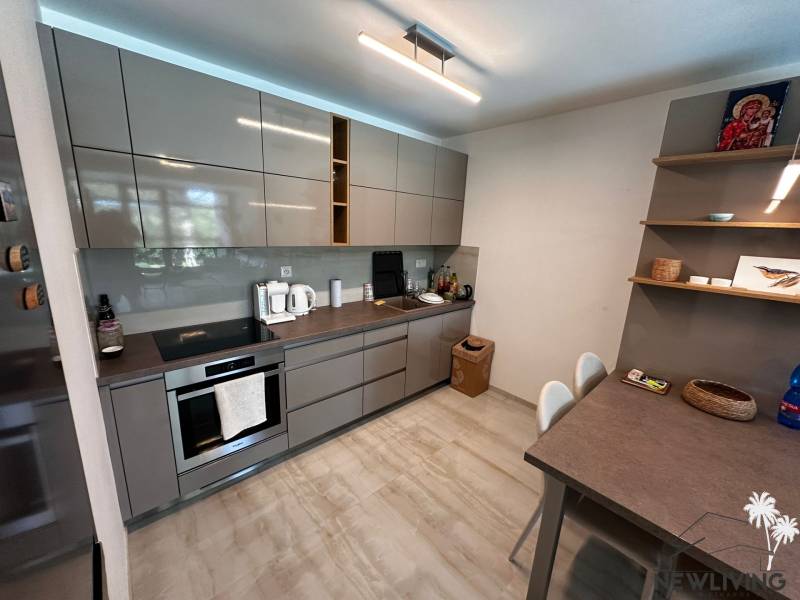 A kitchen in a 2-room apartment with modern grey cabinets and a countertop.
