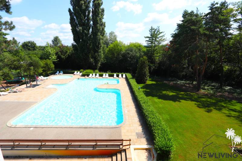 An exterior with a pool and loungers surrounded by greenery on Rekračná Street in Piešťany.