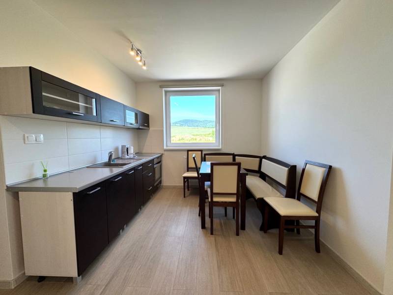 Kitchen in a 3-room apartment with a dining table and a view from the window.