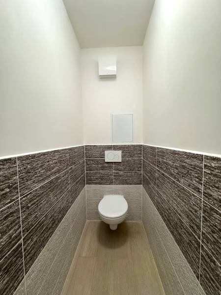 A toilet in a 3-room apartment, tiled with a spacious floor.