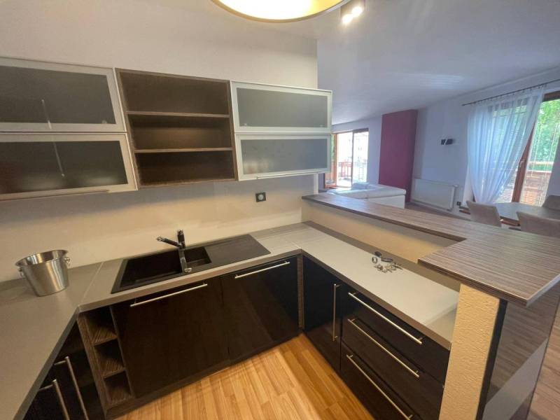 A kitchen in a 3-room apartment with wooden flooring and built-in appliances.