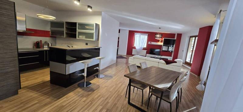 Spacious living room and kitchen with an island in a 3-room apartment with a dining table.