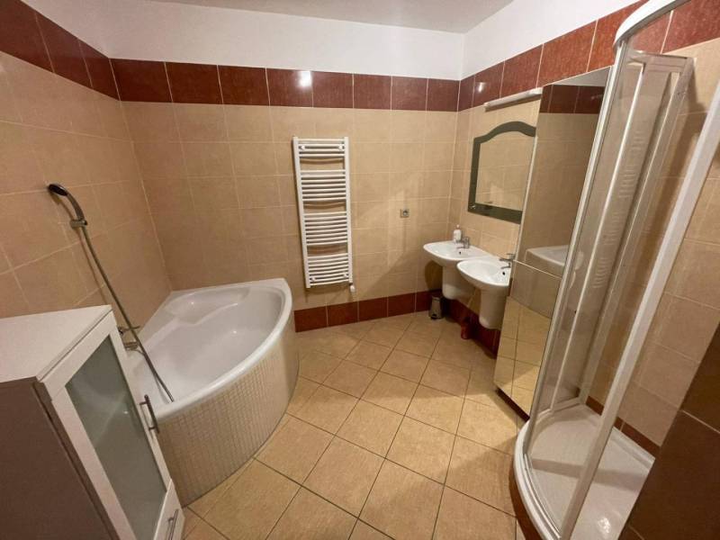 A bathroom in a 3-room apartment with a shower and a bathtub.
