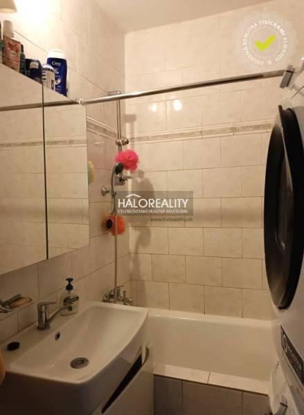 Bathroom in a 3-room apartment with a shower and a washing machine, elegant wall tiles.