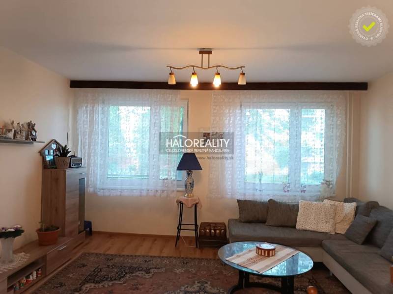 Living room in a 3-room apartment with a sofa, table, and shelf.