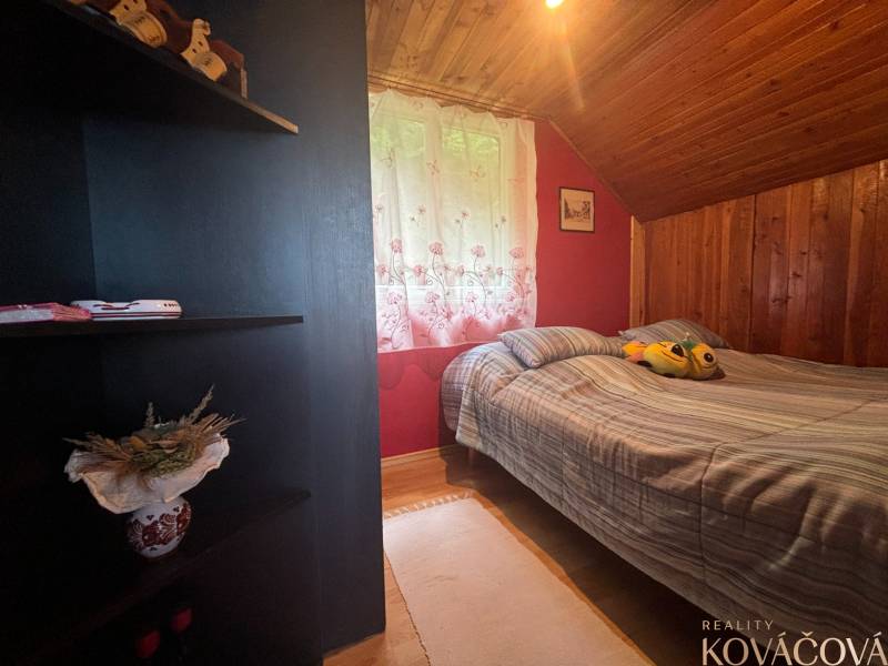 A room in a cottage with a wooden ceiling lining and decorative accessories.