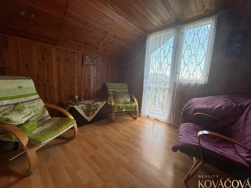 Wooden interior of a cabin with comfortable armchairs and glass doors with a view.