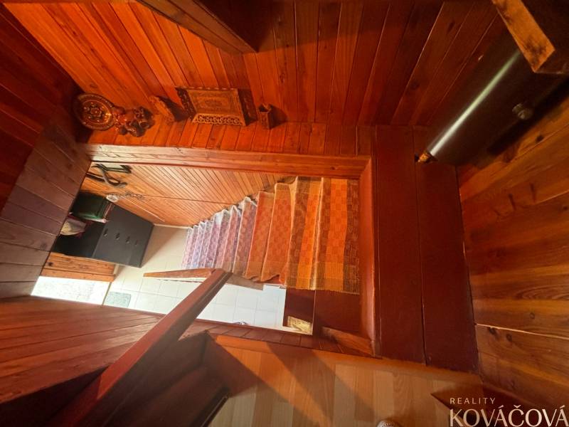 Wooden stairs with carpet in the interior of the cottage, decorative elements highlight the coziness.
