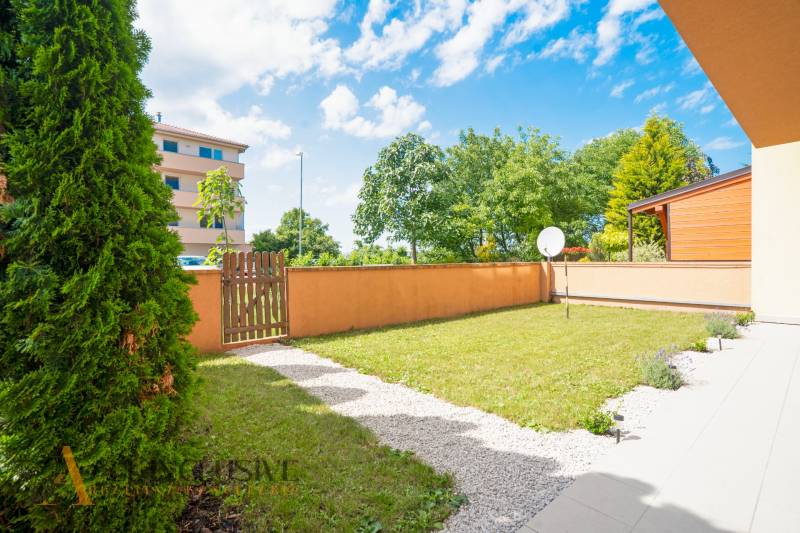 A landscaped garden with a lawn and a wooden fence at a 2-room apartment.