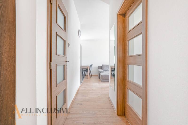 Hallway in a 2-room apartment with wooden doors and a mirror.