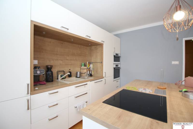 Kitchen in a 2-room apartment with a wooden countertop and a stove.