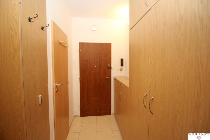 The entrance hall of a 2-room apartment with wooden furniture and tiled flooring.