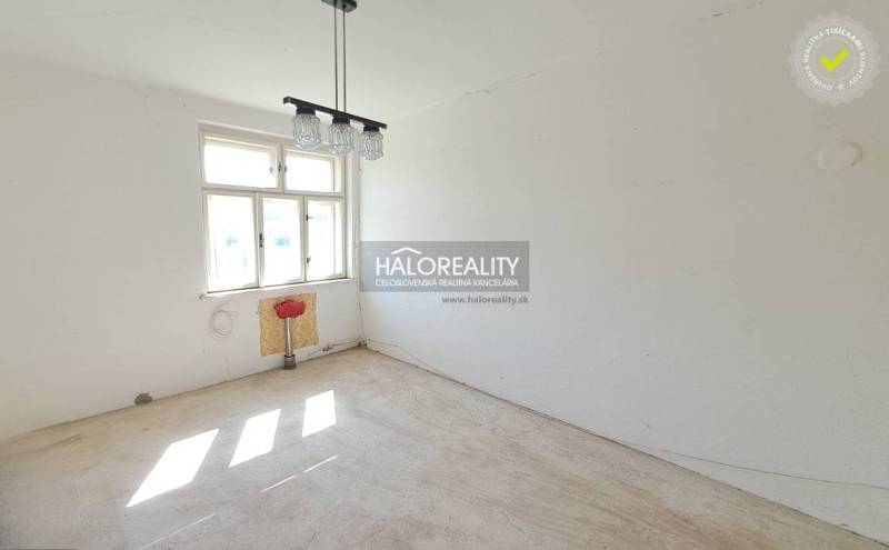 A room in a family house with a large window and lighting.