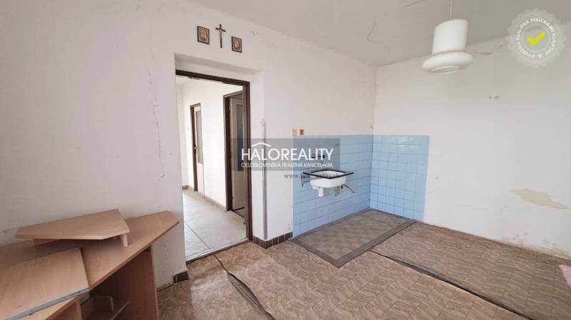 An interior with a sink, blue tiles, and open doors in a family house.