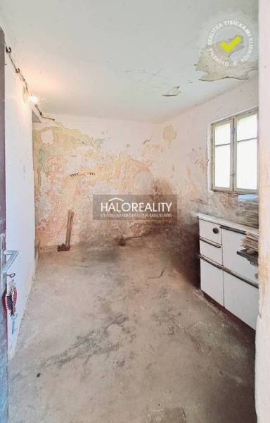 An abandoned room with old furniture and cracked walls in a family house.