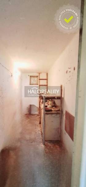 A narrow corridor with an old kitchen unit in a family house.