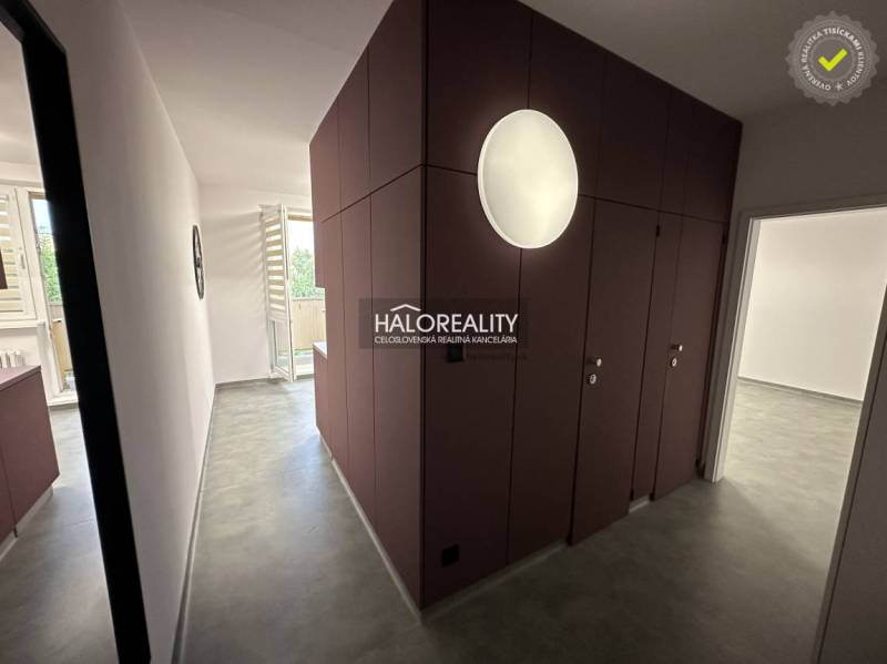 A kitchen in a studio apartment with balcony doors, a radiator, and appliances.