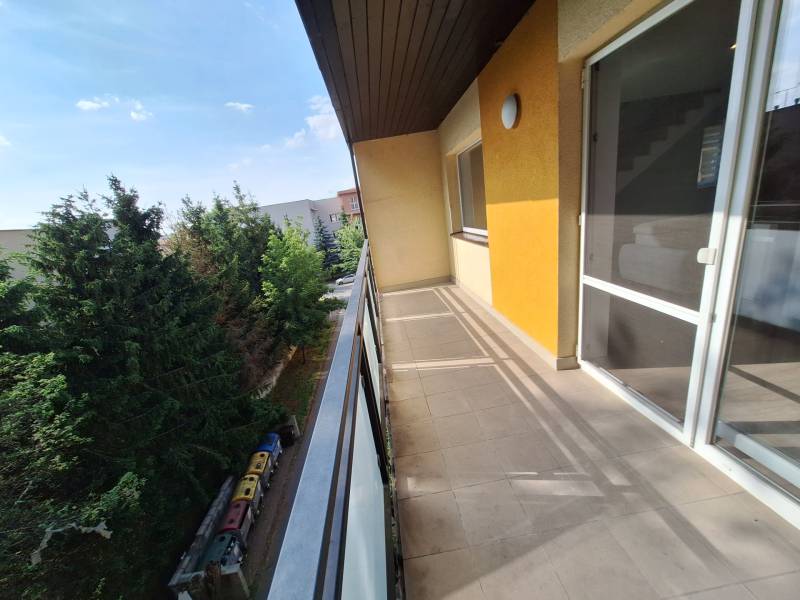 The balcony of a 4-room apartment in Prešov with a view of trees and the courtyard.