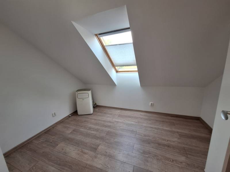 Attic room with wooden flooring and a skylight in a 4-room apartment.