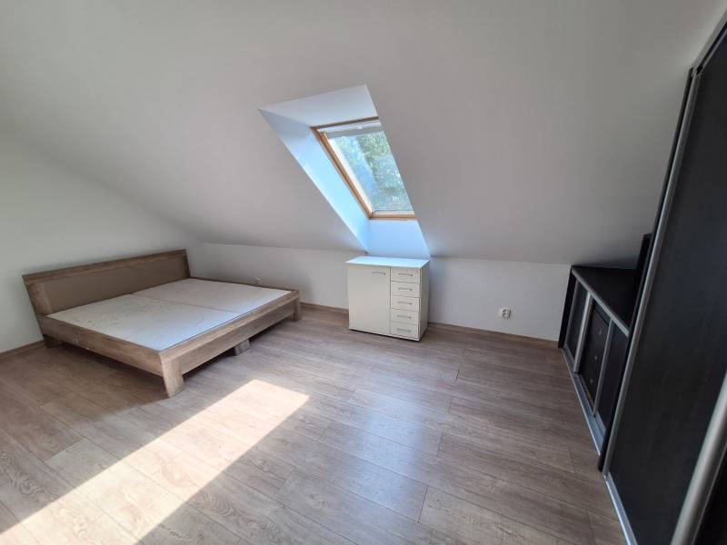 Attic room with a skylight, bed, dresser, and wardrobe in a 4-room apartment.