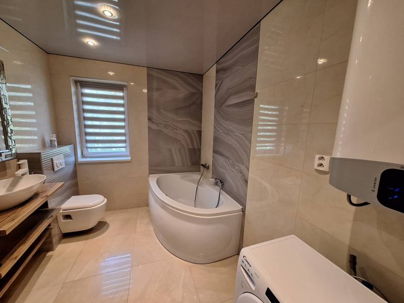 Bathroom in a 4-room apartment with a shower and a washing machine.