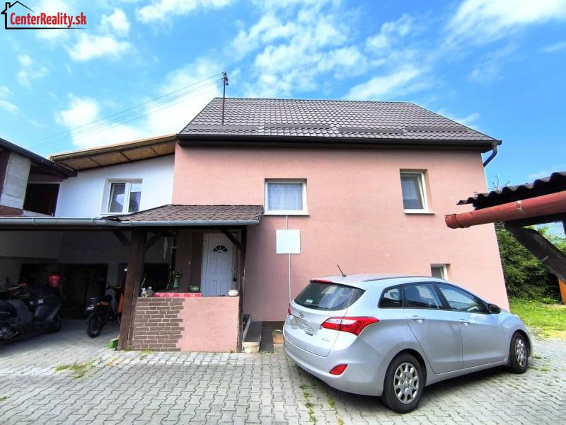 A family house in Nitrica with a driveway and a parked car in the yard.
