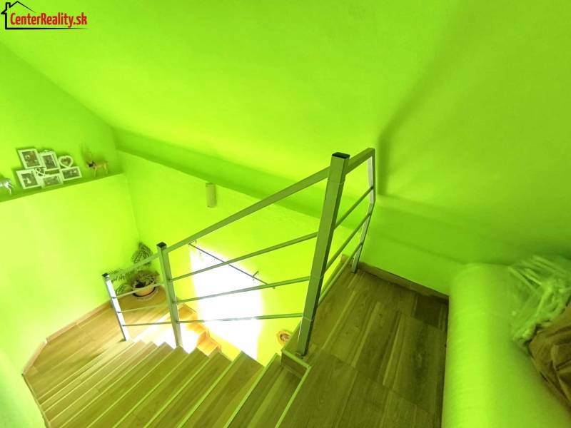 Light green staircase with wooden steps and decorations in a family house.