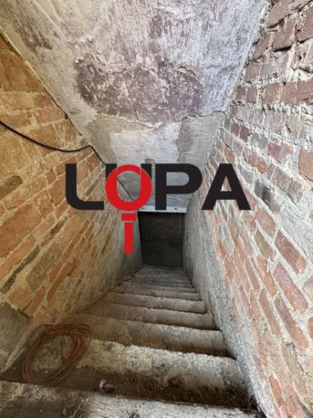 The staircase leading to the basement in a family house with brick walls.