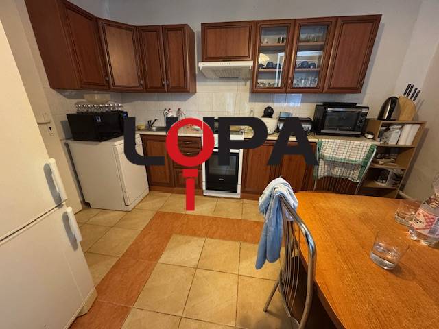 A kitchen in a family house with wooden cabinets, a stove, and a refrigerator.