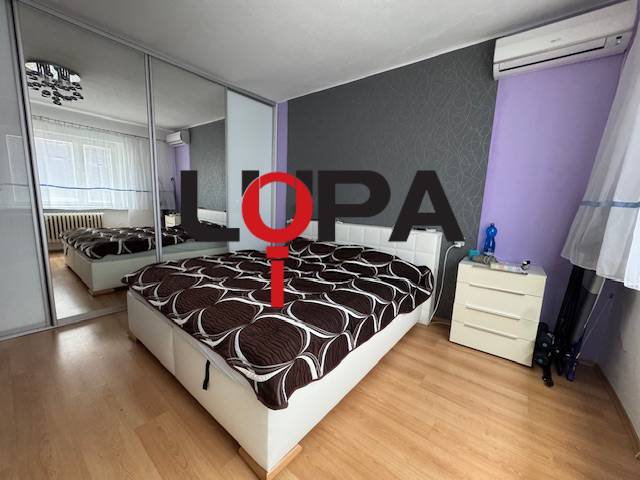 Bedroom in a family house with a bed and a mirrored wardrobe.