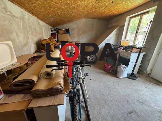 Attic storage space with a bicycle and cardboard boxes in a family house.