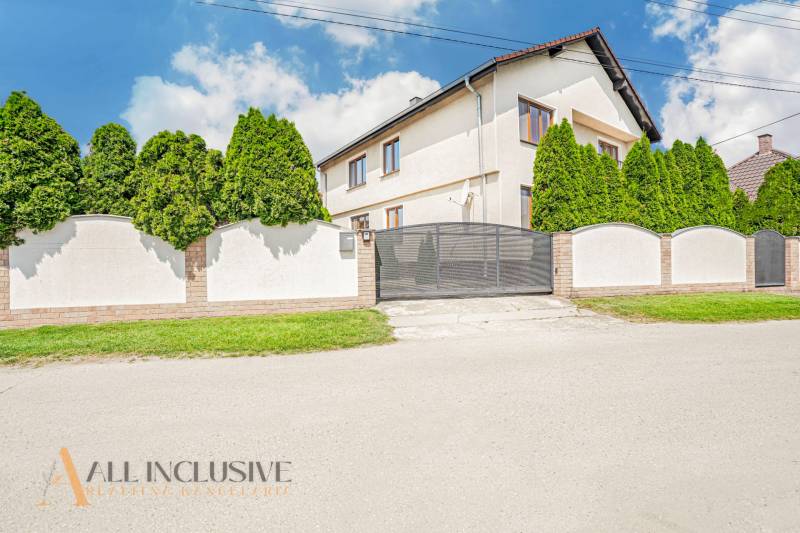 A family house in Sapa with a white facade, a gate, and trees in the front garden.