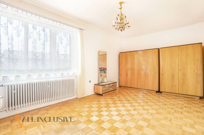 Bright room with wooden floor, wardrobes, and a mirror in a family house.