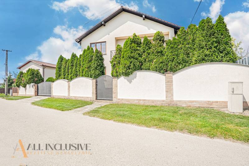 A family house in Sapa with a white fence and landscaped greenery.